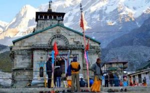 Scenic view of Kedarnath temple with snow-covered hills in the background – part of Chardham tour package.