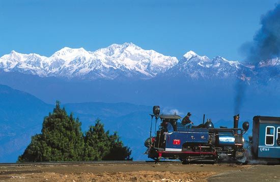 Snow-covered hills of Mukteshwar, Uttarakhand with lush green trees and scenic mountain views.