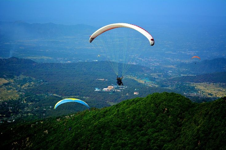 alt="Paraglider launching from hilltop with Bhimtal in the background-Paragliding near Nainital"