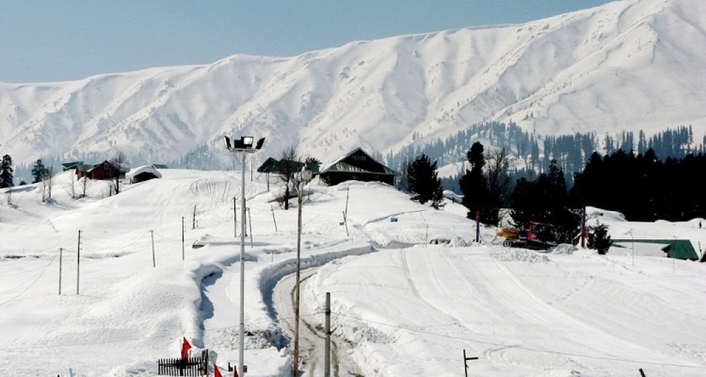 alt="Panoramic winter view of snow-capped Himalayan peaks from Snow View Point in Nainital - clear blue skies framing majestic white mountains"
