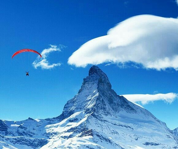 alt="Distant mountains with a paraglider in flight—gives a "wild and remote" adventure feel"- Paragliding near Nainital"