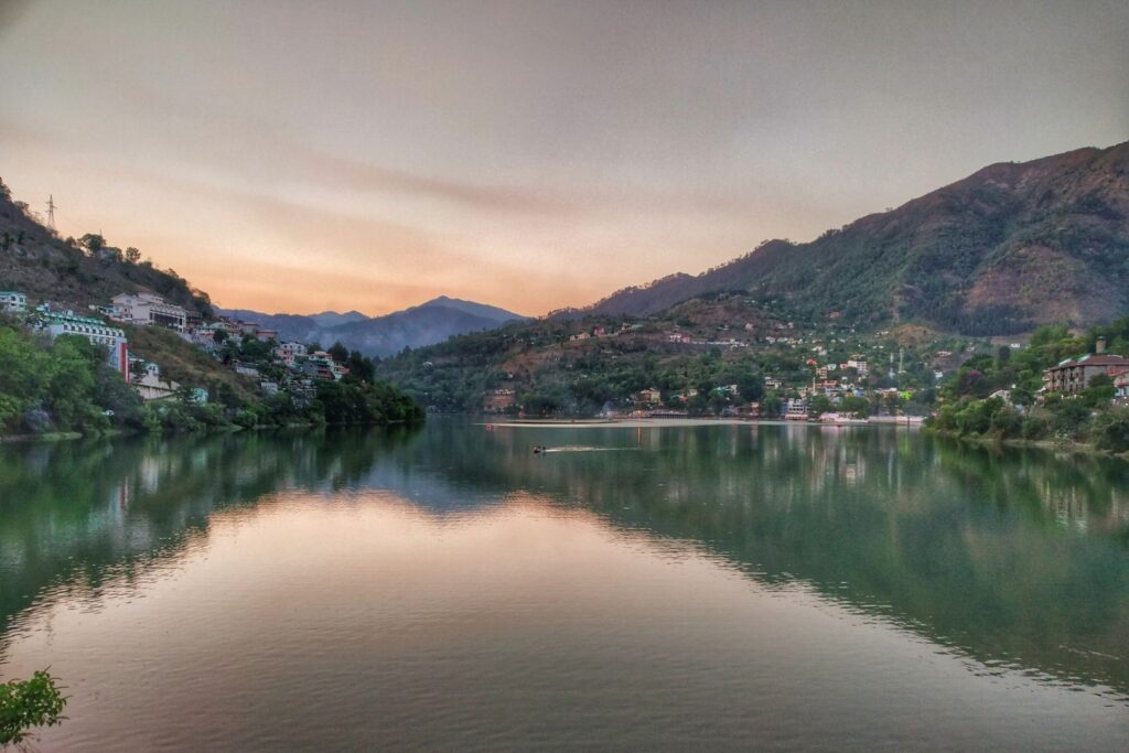 alt="Serene canoe on Bhimtal Lake at sunrise – peaceful boating in Uttarakhand near Nainital"